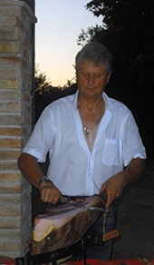 foto dell'esterno dell'agriturismo villa rosa mentre una persona sta affettando un prosciutto di mora romagnola di nostra produzione